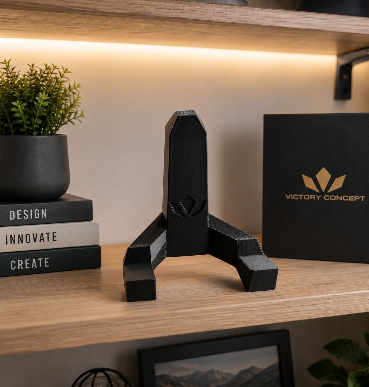 Soporte de mesa Victory Concept sobre una repisa junto a libros y una planta